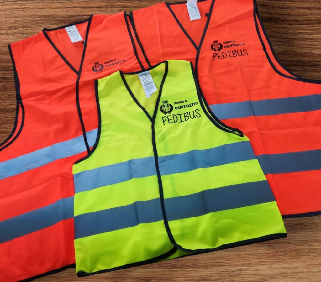 Gilet alta visibilità personalizzati con stampa lato cuore arancio e gialli, progettati per il comune e l’attività “pedibus” dei bambini della scuola.